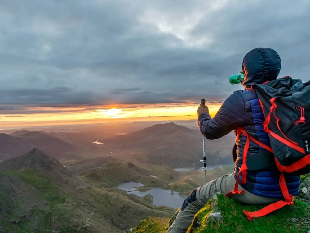 Hikers traversing dramatic mountain ridges in Snowdonia National Park, Wales, during the Welsh 3000s Challenge with sweeping views of rugged peaks