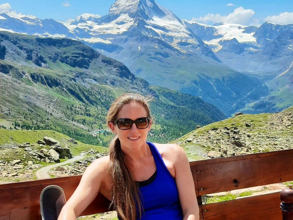Smiling hiker relaxing on a mountain hut terrace with the Matterhorn behind
