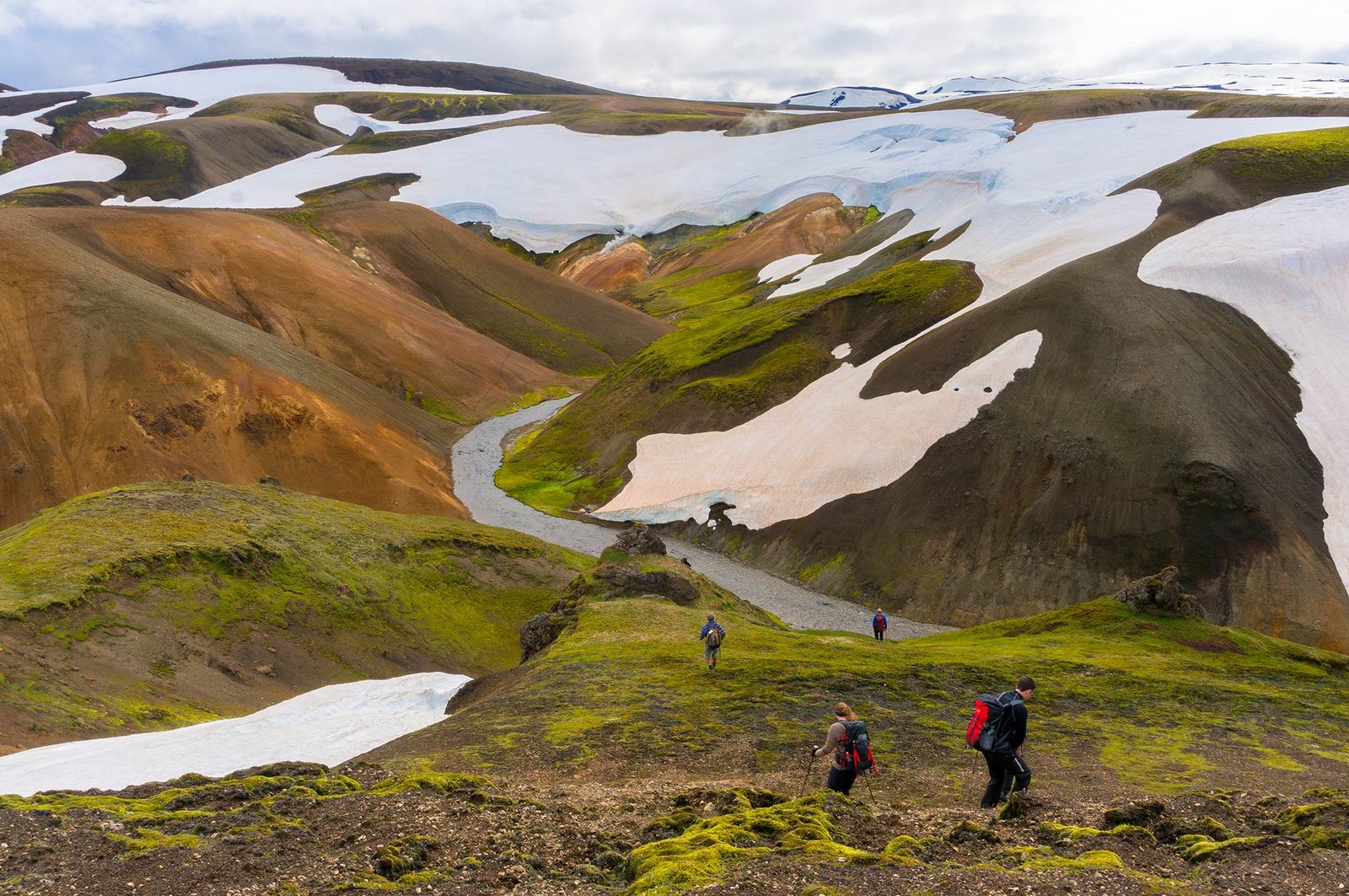Hikers in colorful volcanic landscape