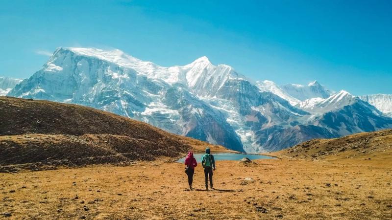 couple walk towards lake at Annapurna Circuit Trek