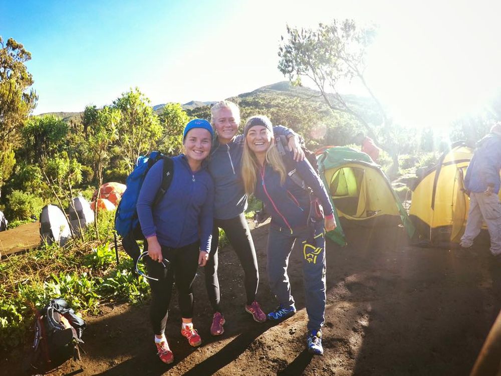 Three happy trekkers smiling at camera on Kilimanjaro