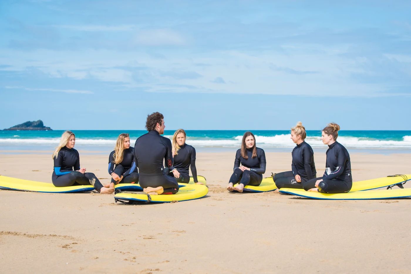 A group of happy beginners learning to surf.