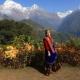 lady in traditional dress stands in front of an Annapurna viewpoint