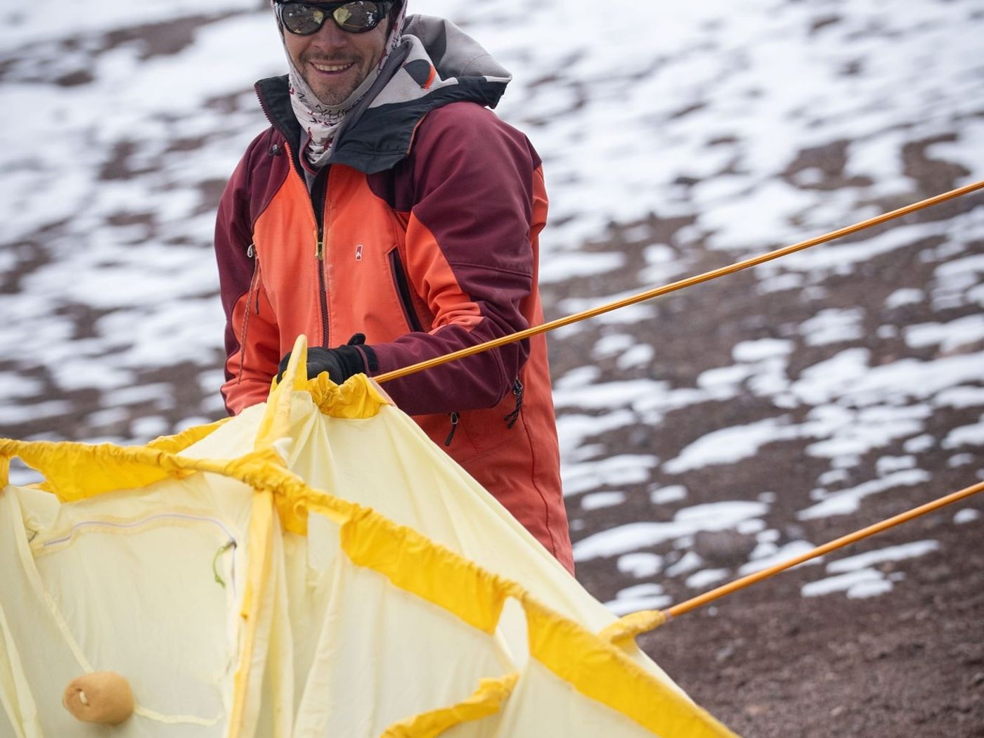 Climber setting up tent in snowy mountain camp on Aconcagua