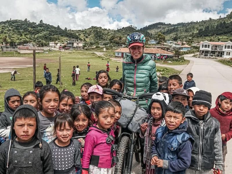 Bikepacker on mountain bike with school children