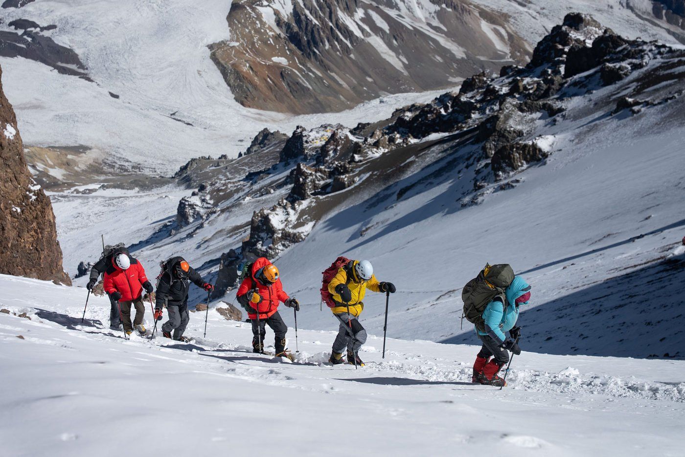 Climbers ascending snowy slope with panoramic Andes views