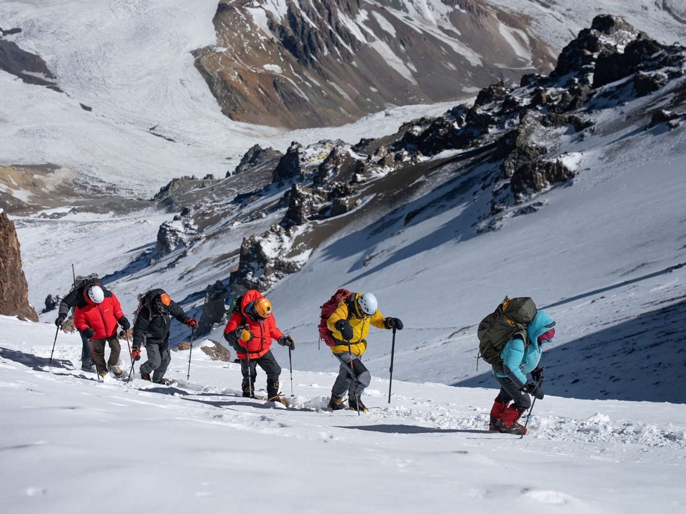 Climbers ascending snowy slope with panoramic Andes views