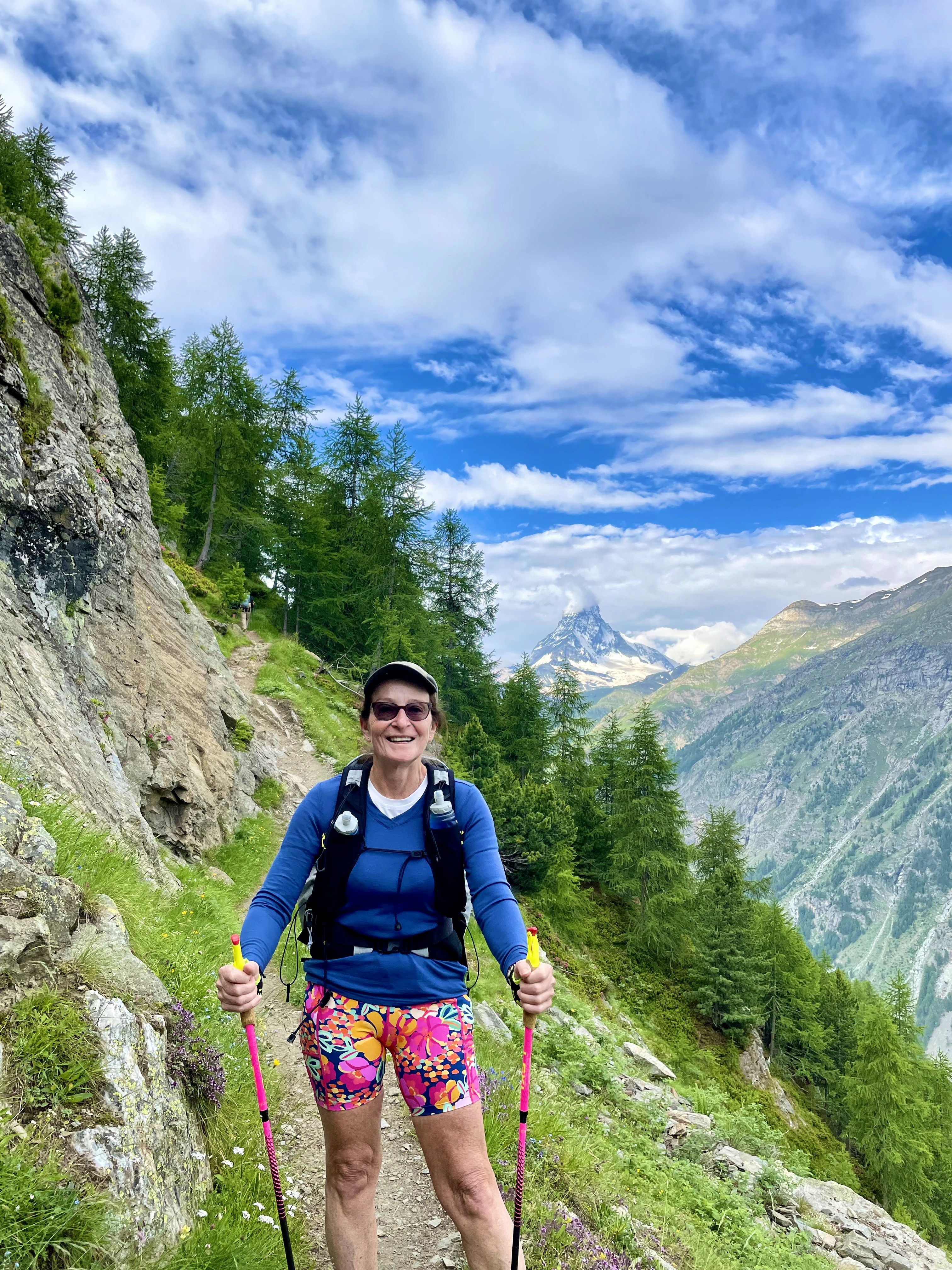 Smiling hiker on a forest trail with the Matterhorn visible behind