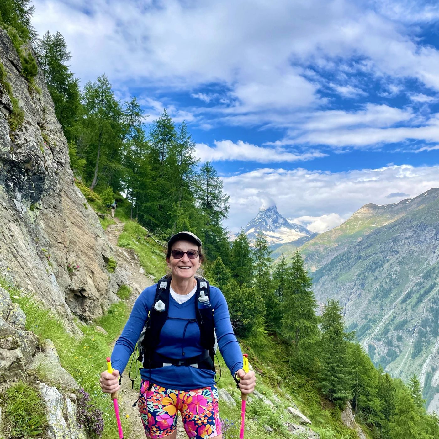 Smiling hiker on a forest trail with the Matterhorn visible behind
