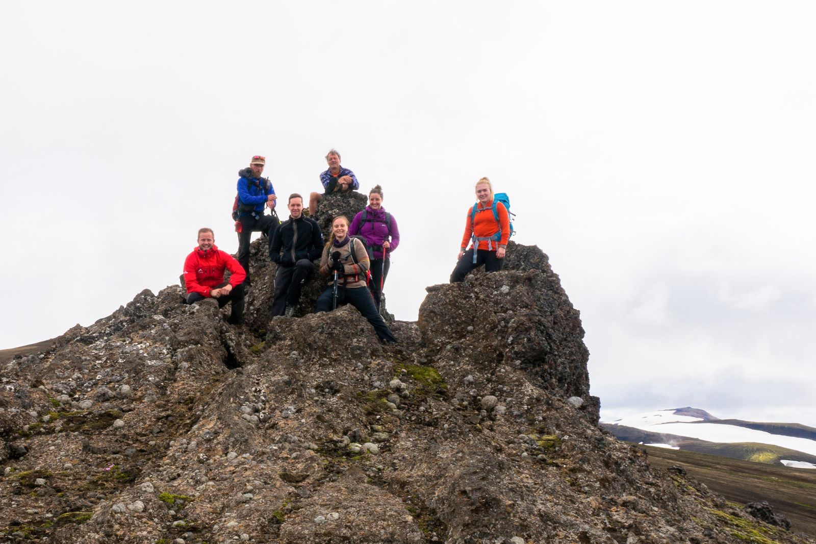 Hiking group celebrating at mountain peak summit