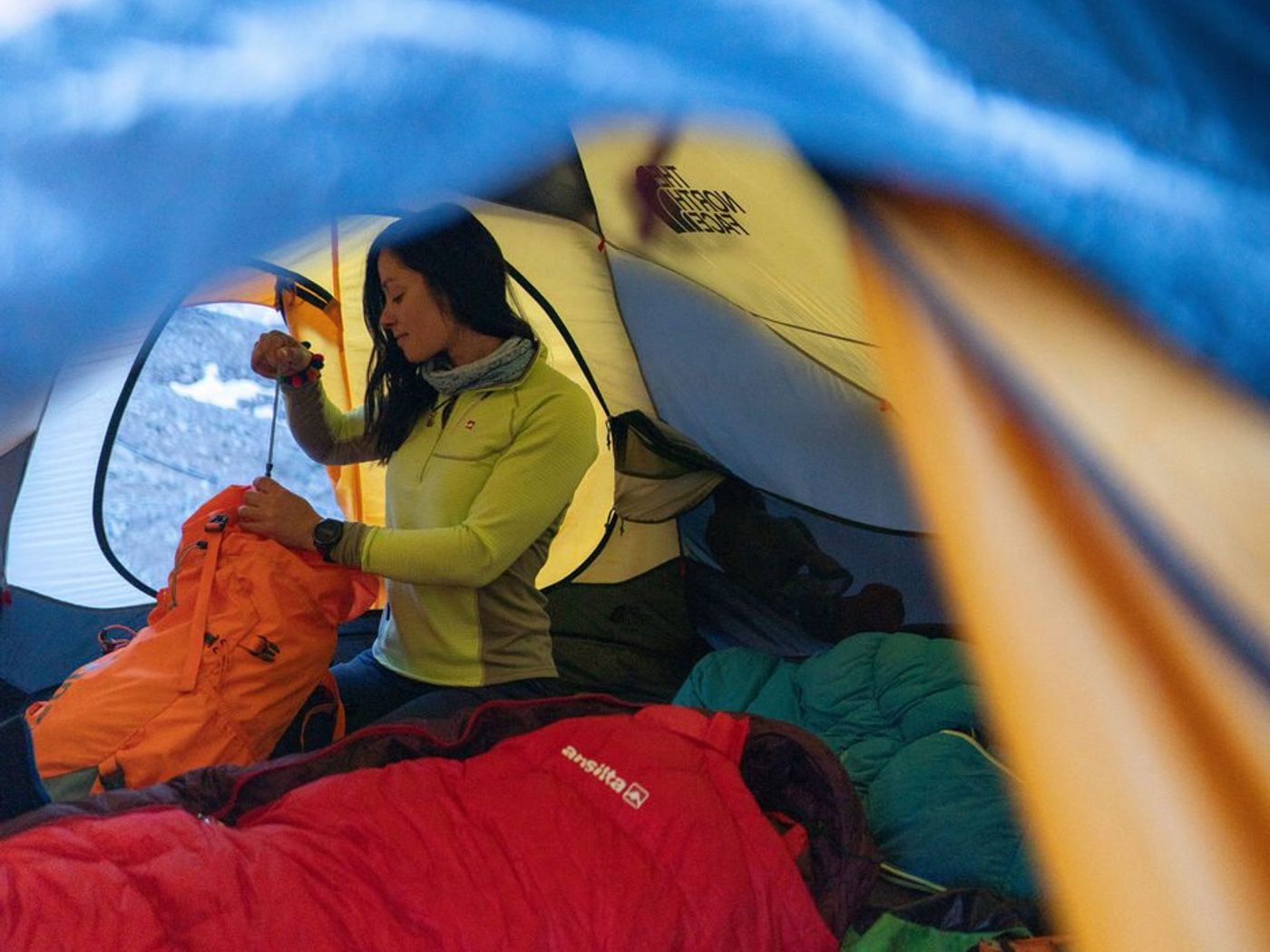 Woman packing gear outside tent on Aconcagua expedition