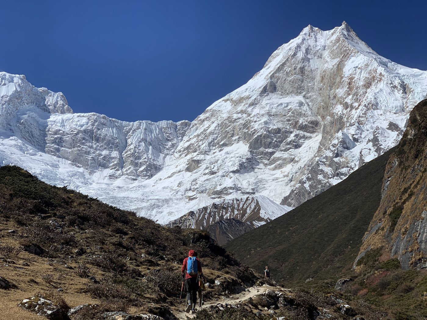 Hiker walking towards the north face of Manaslu above Samagaon