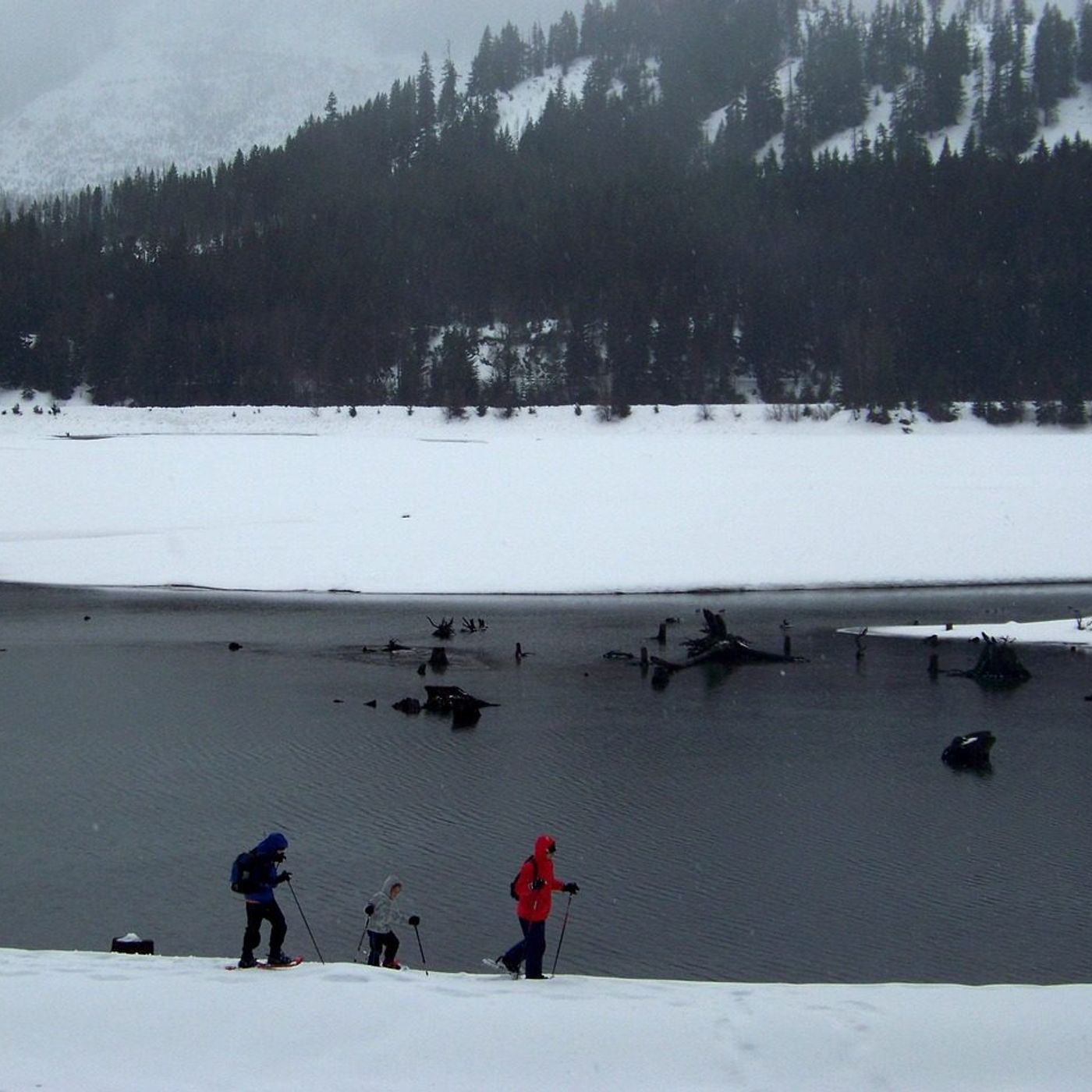 Snowshoeing by a frozen alpine lake