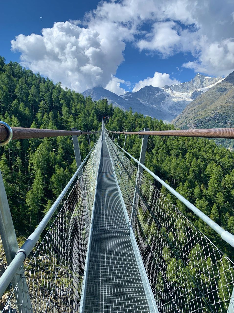 Full suspension bridge landscape with autumn colours and snow peaks
