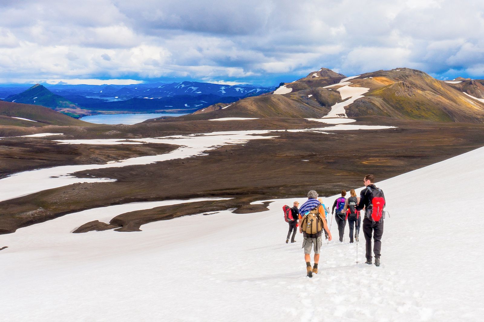 Stunning panoramic view of Iceland's volcanic highlands with dramatic mountains, glaciers, and colorful terrain stretching to the horizon