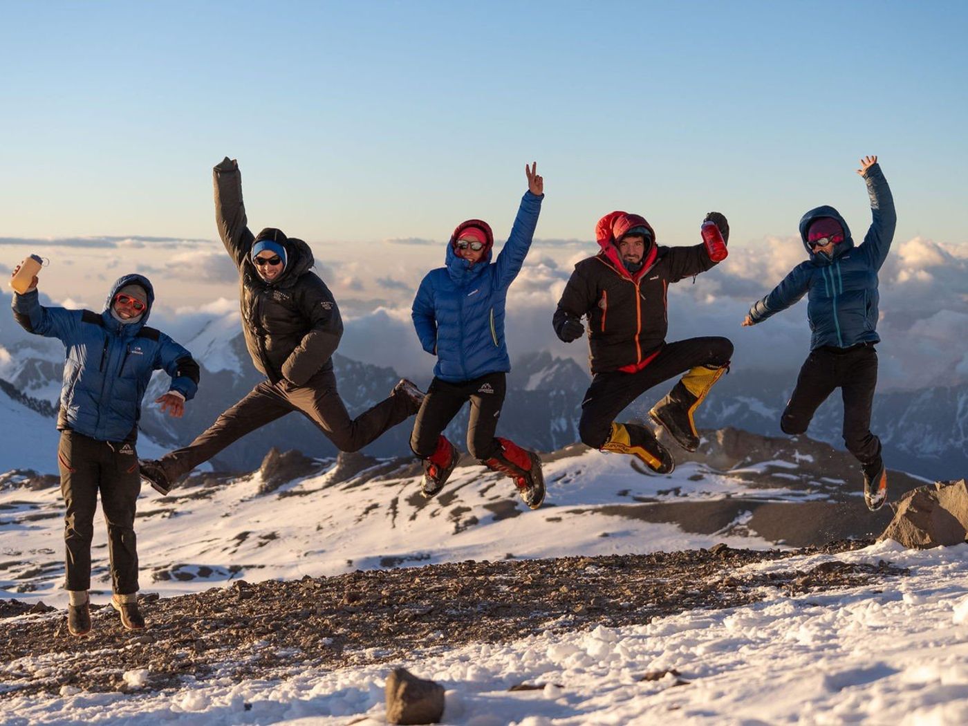 Climbers jumping at the peak of Mount Aconcagua