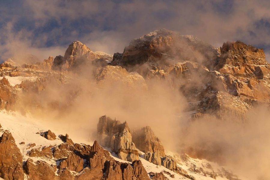 Aconcagua mountain peaks emerging through fog at sunrise