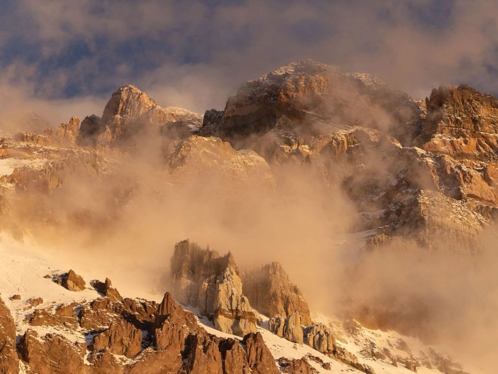 Aconcagua mountain peaks emerging through fog at sunrise