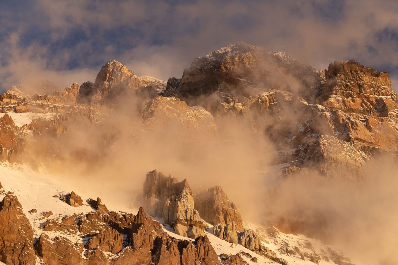 Aconcagua mountain peaks emerging through fog at sunrise