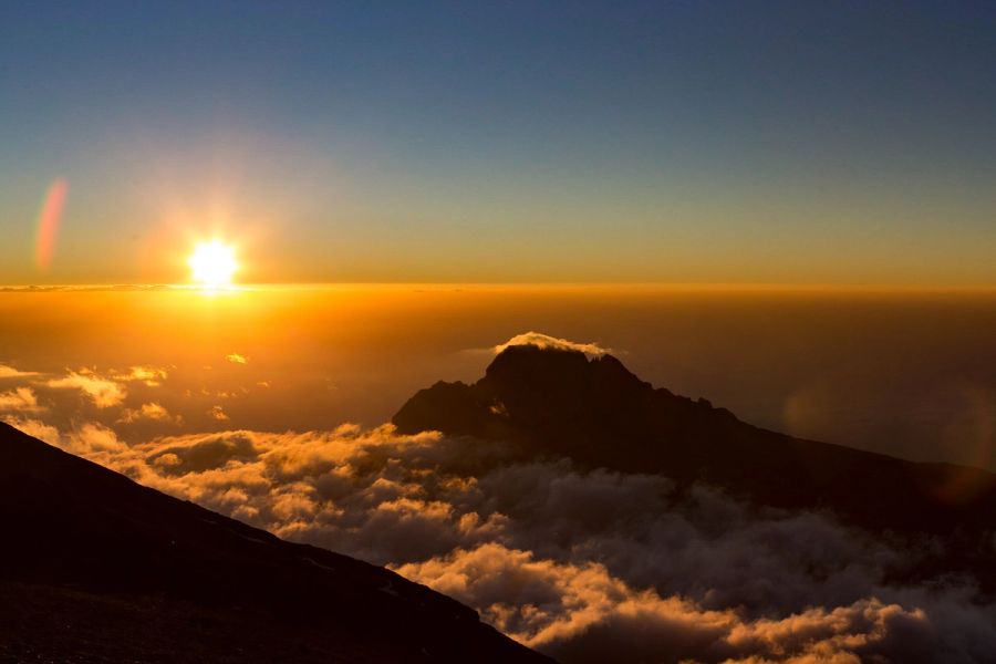 Sunrise over Kilimanjaro summit with clouds below