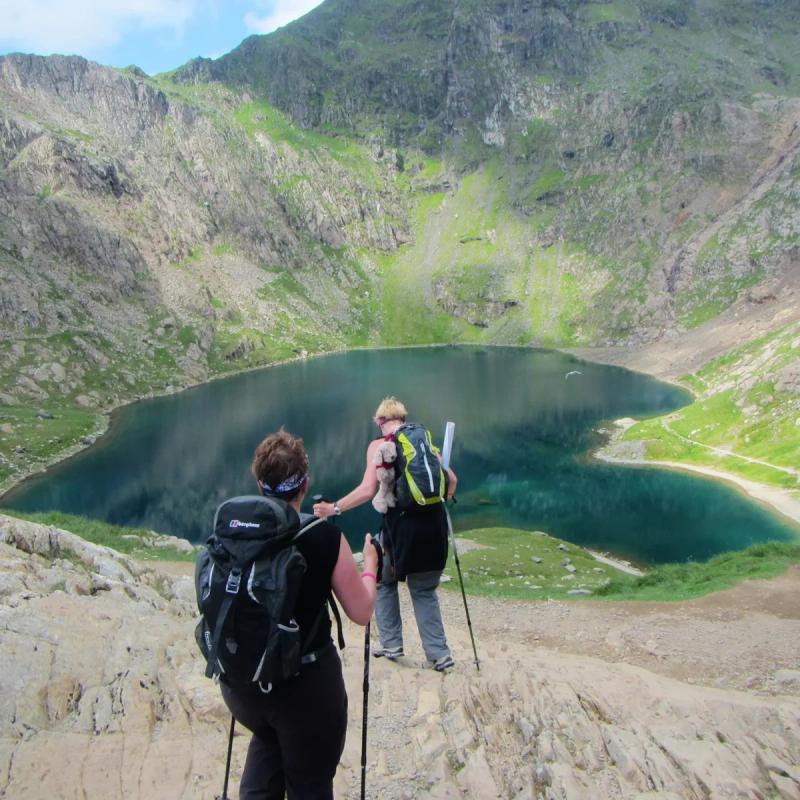 Hikers hiking over lake in Snowdonia