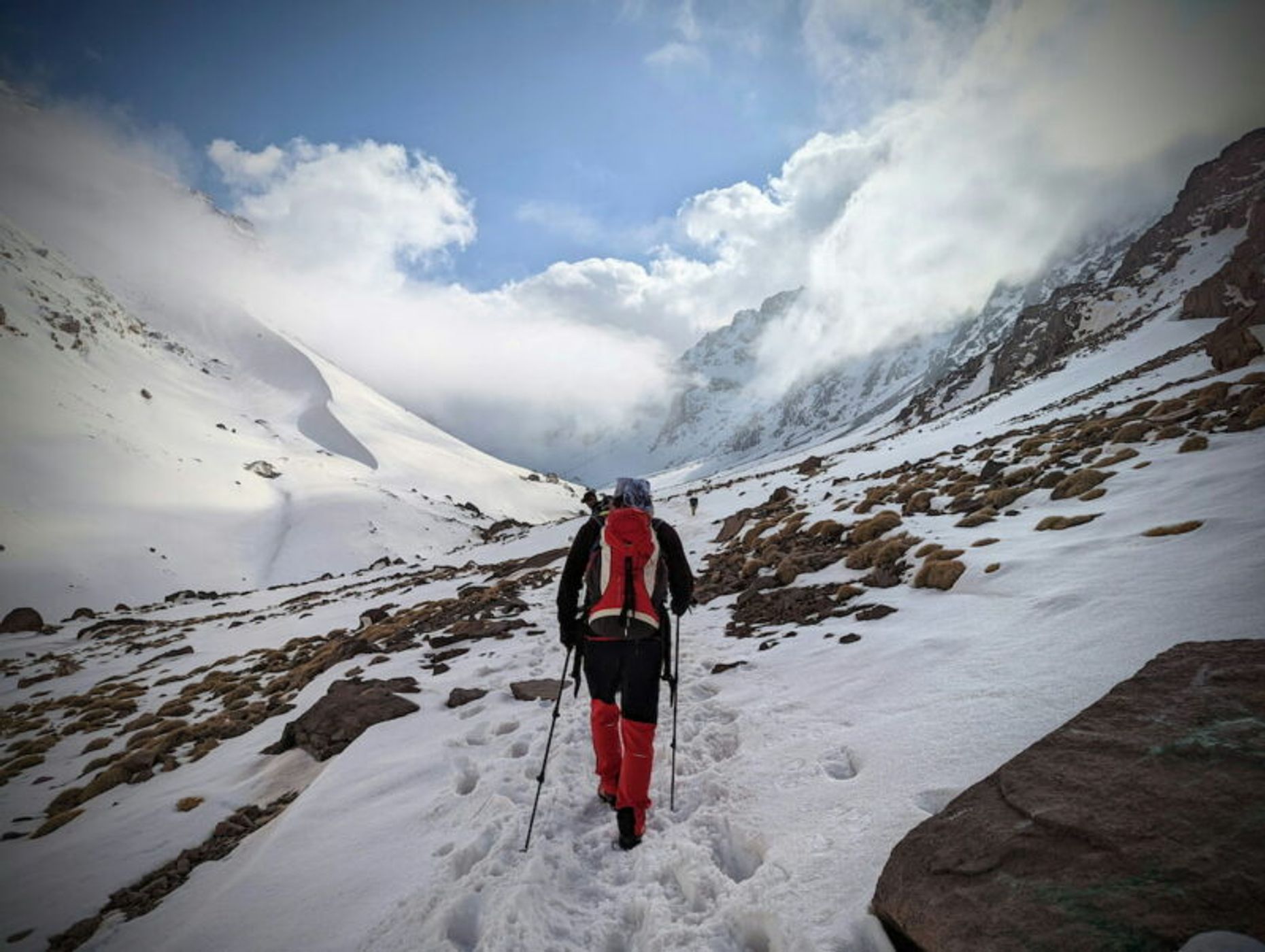 trekker walking in snow towards toubkal summit