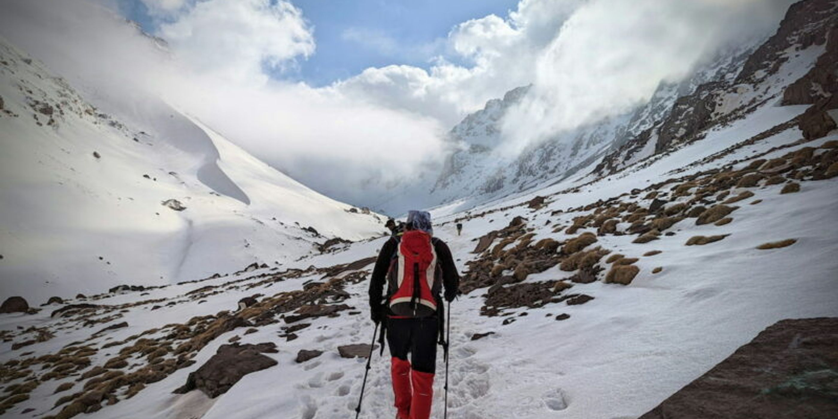 trekker walking in snow towards toubkal summit