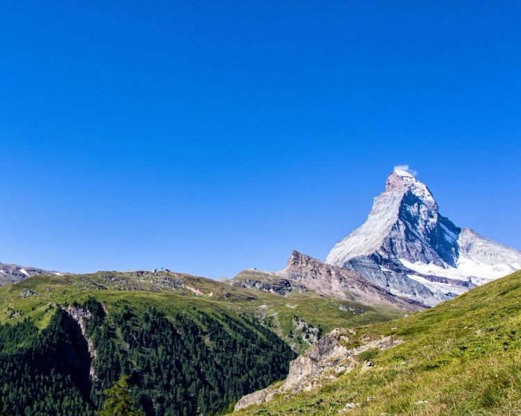 Classic Matterhorn peak with Zermatt village below and blue sky