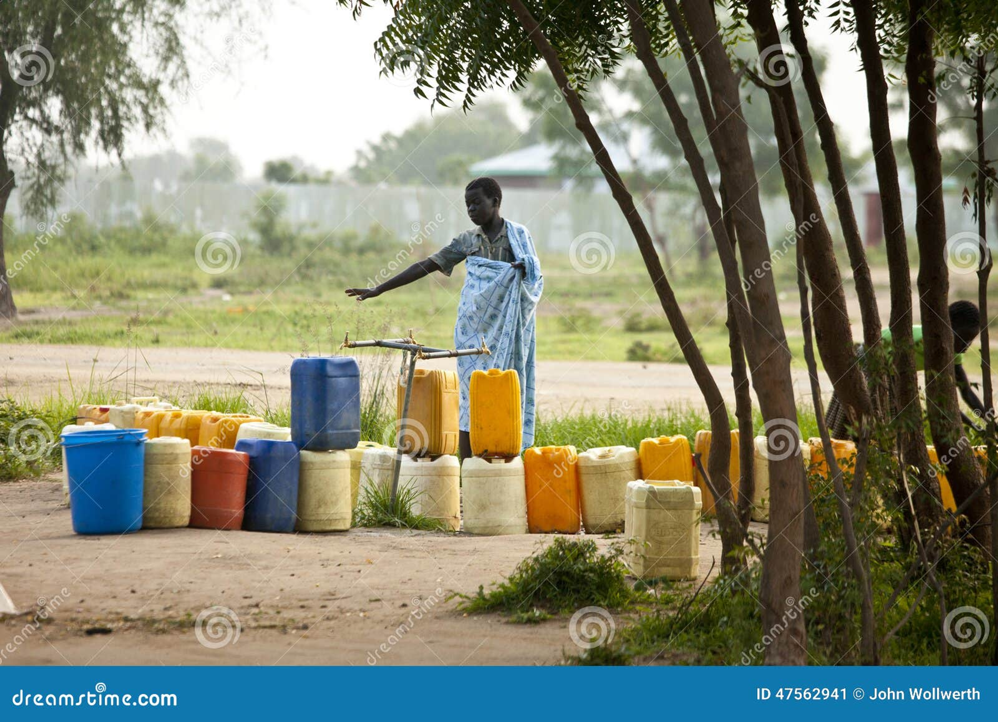 Una mujer esperando con garrafas de agua en un punto de agua en Bor, Sudán del Sur.