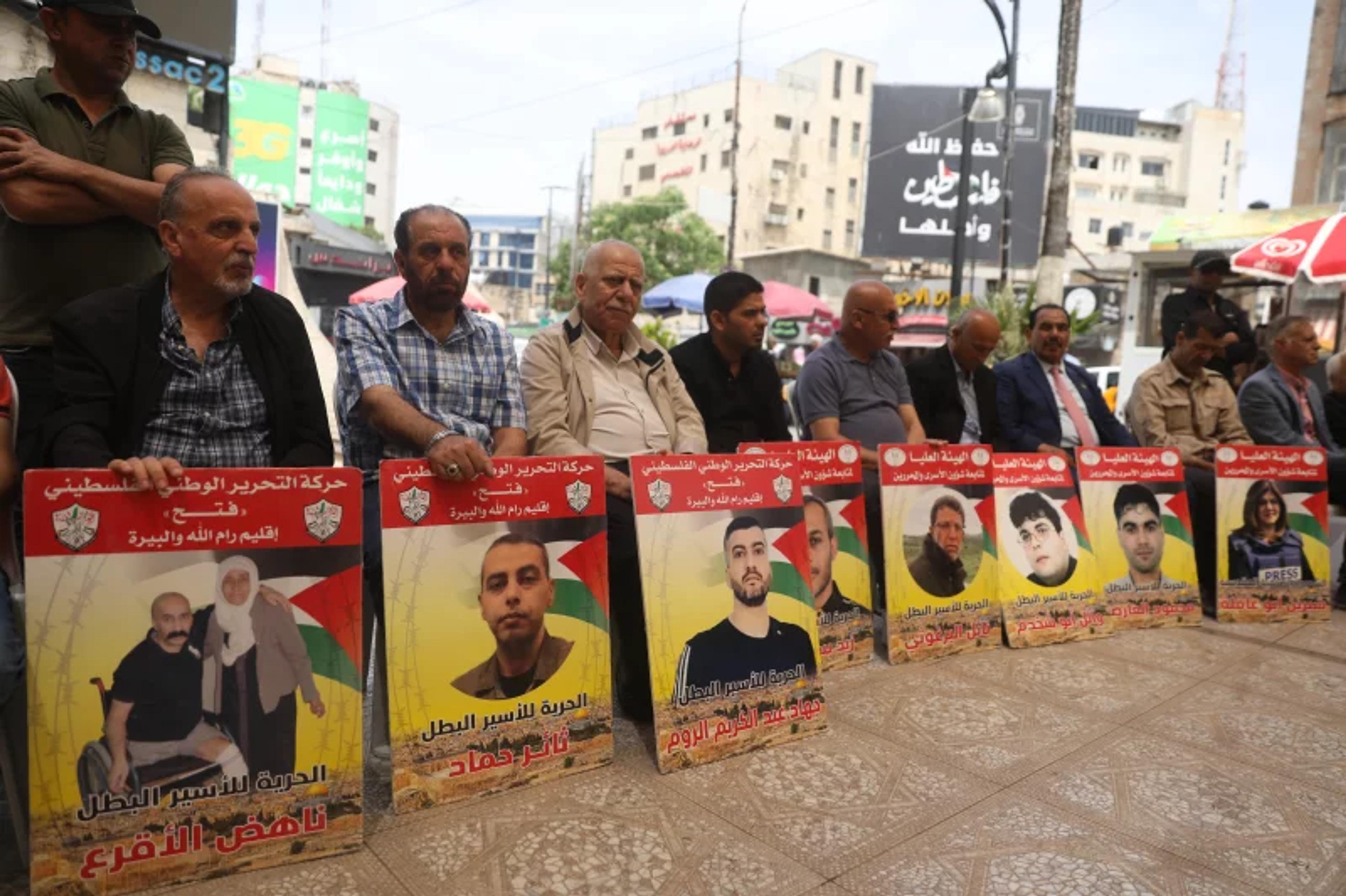 Relatives of Palestinians detained in Israeli prisons demonstrate in front of the Al-Bireh Cultural Center building in Ramallah