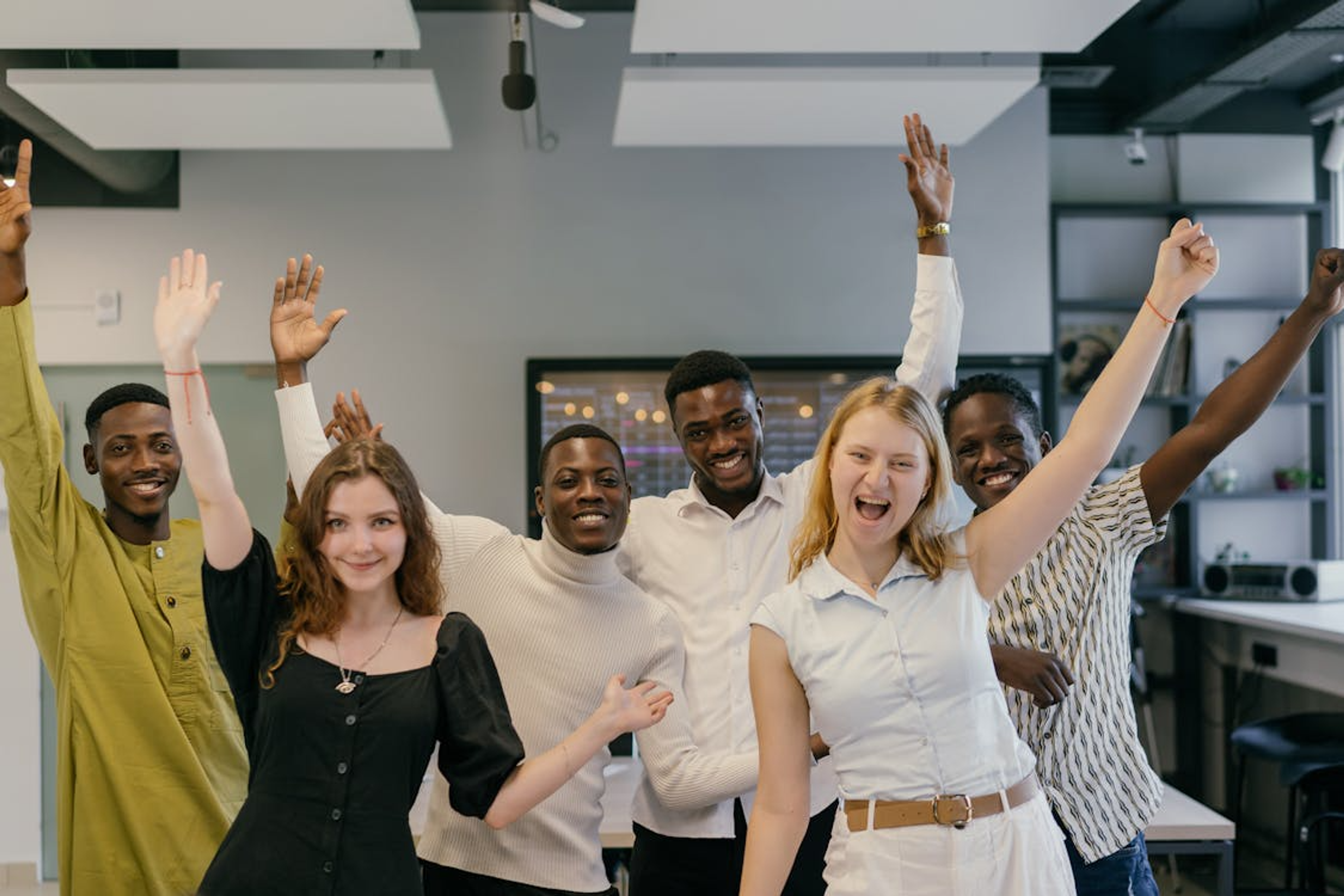 Diverse team celebrating in a modern workplace.