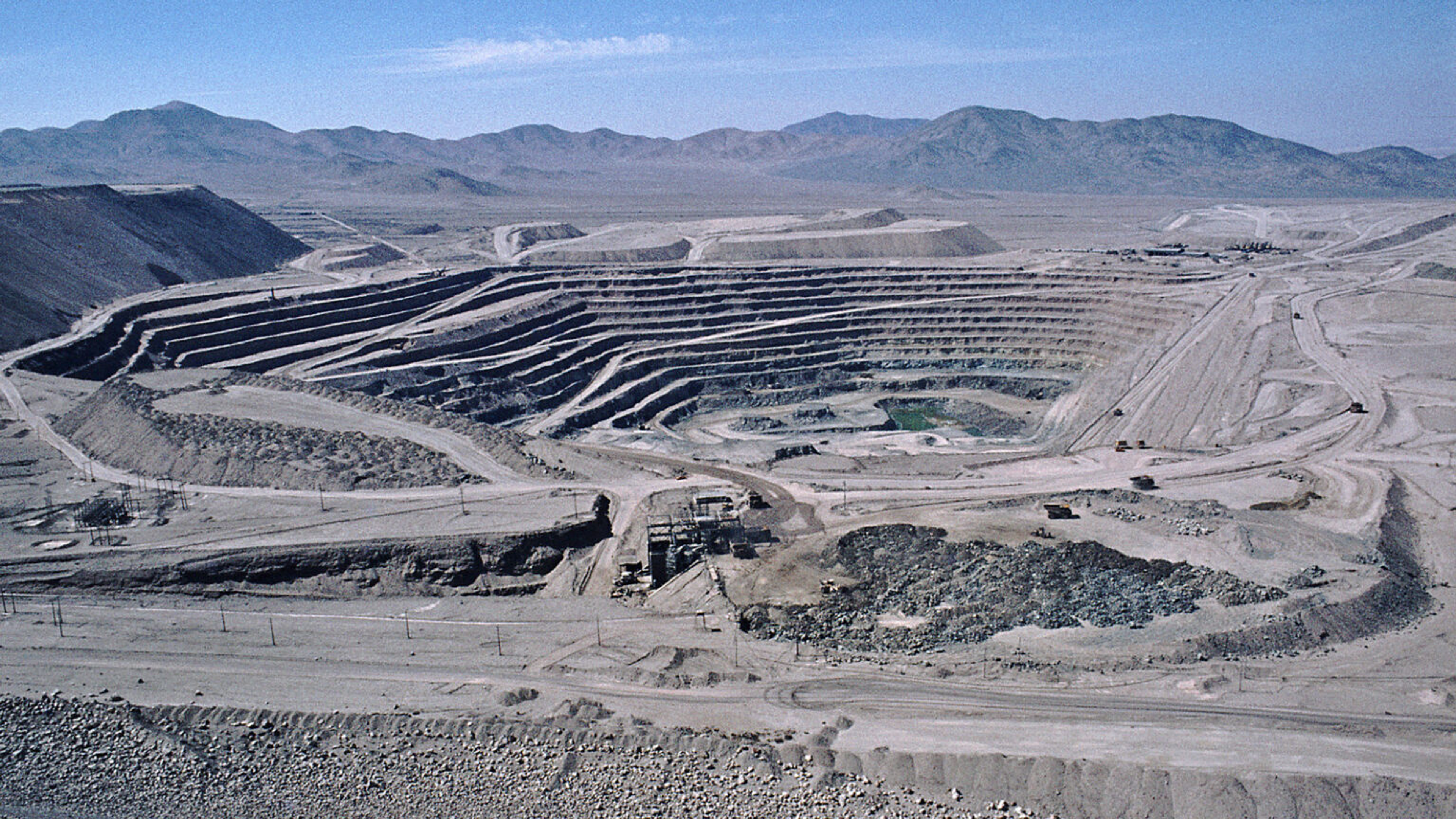 Large open-pit mine in a remote, barren landscape.