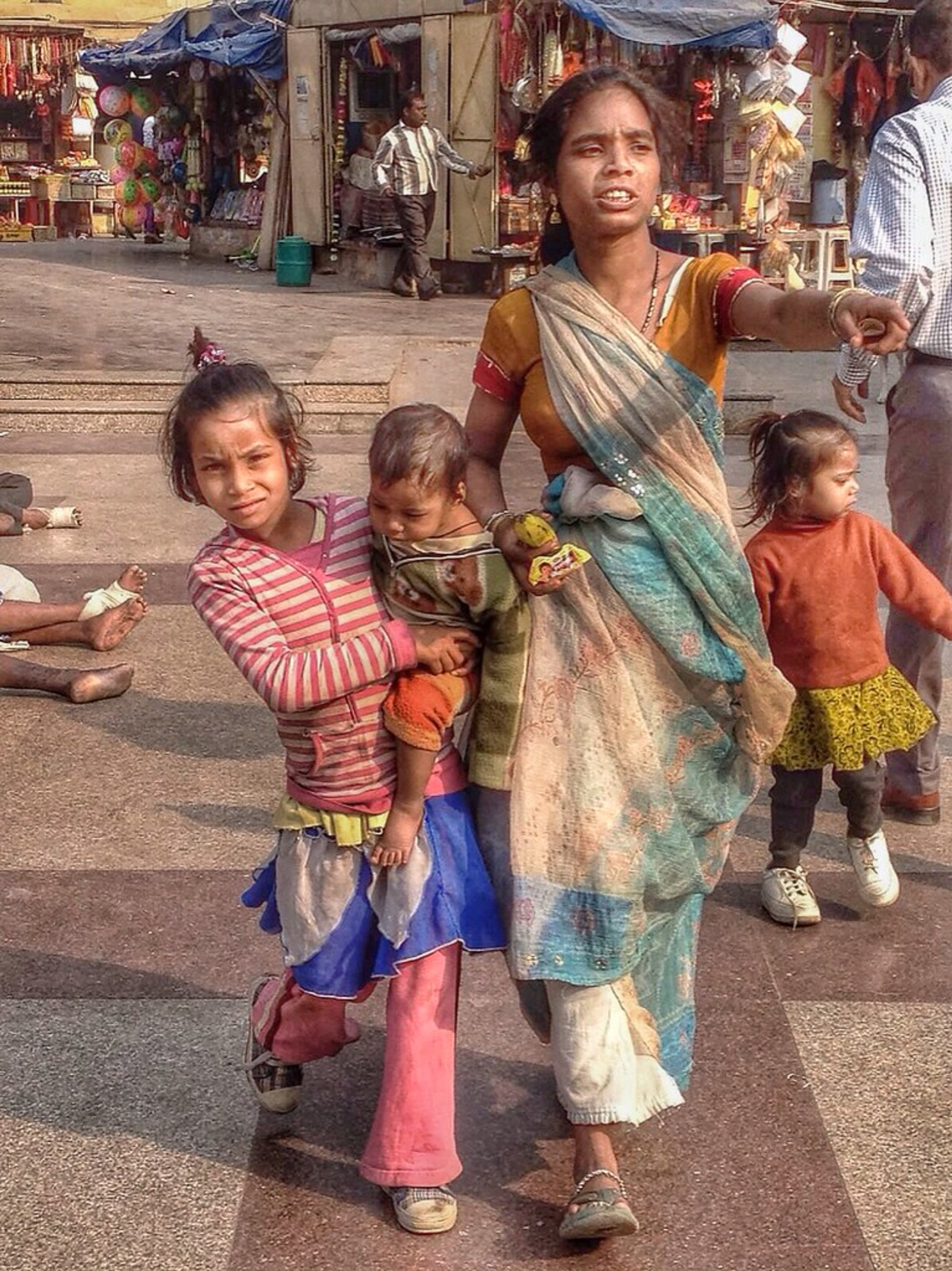 Gen Z youth protest in South Asia with family in a busy street.