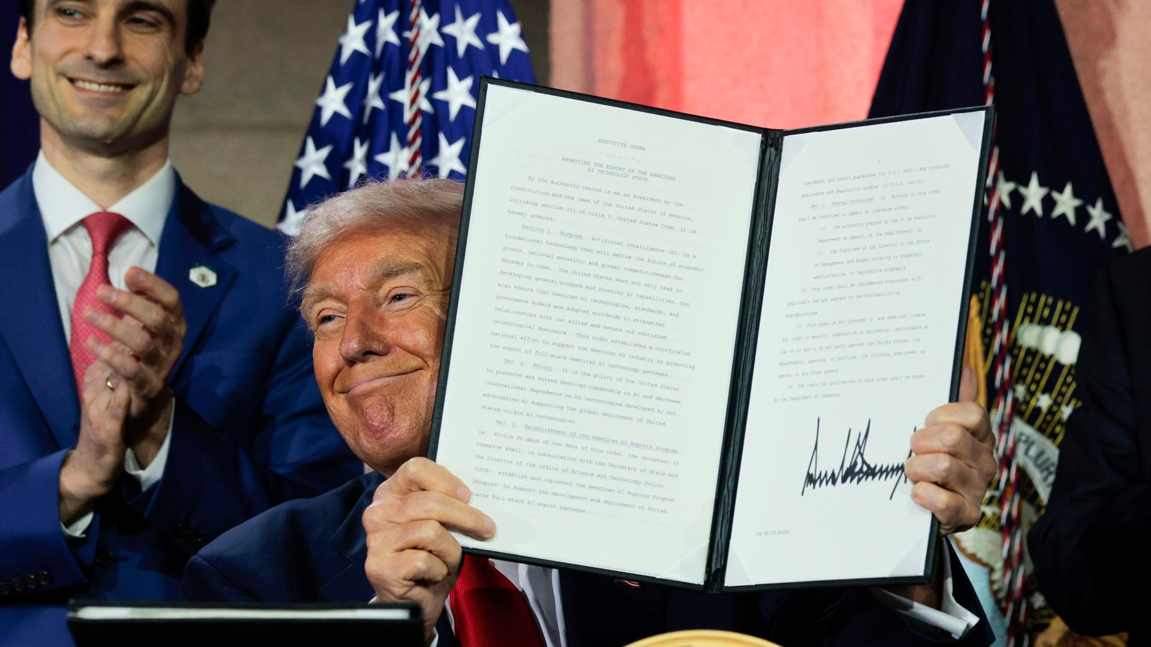 El presidente Trump muestra una orden ejecutiva firmada.