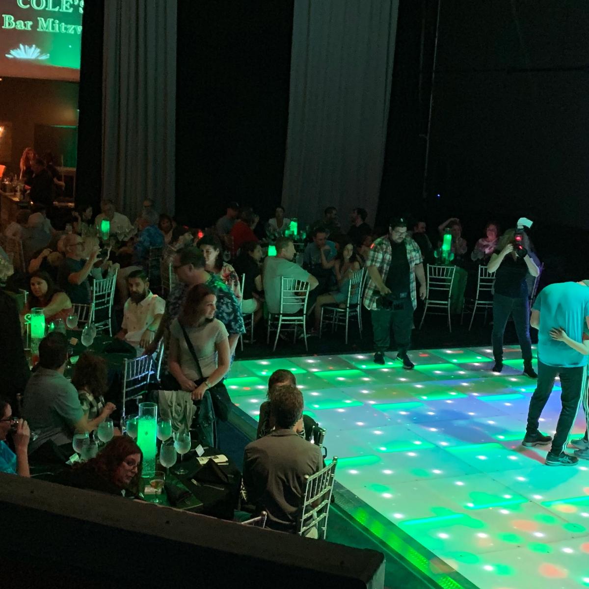 Bar mitzvah dance floor with green and purple uplighting