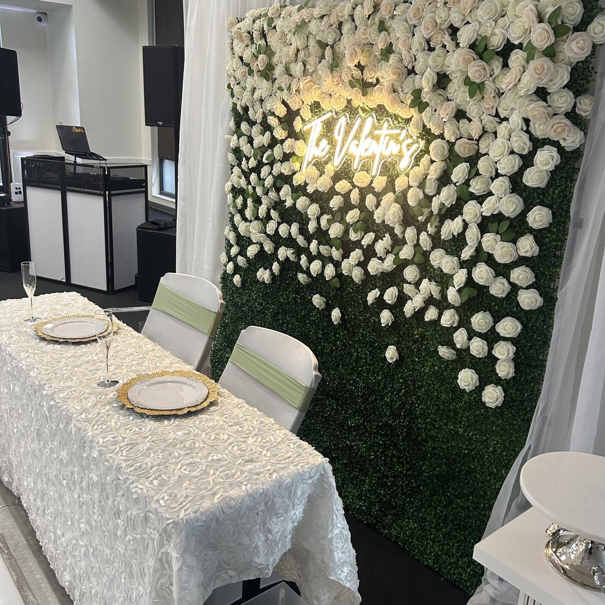 Hedge wall backdrop with a rosette linen sweetheart table