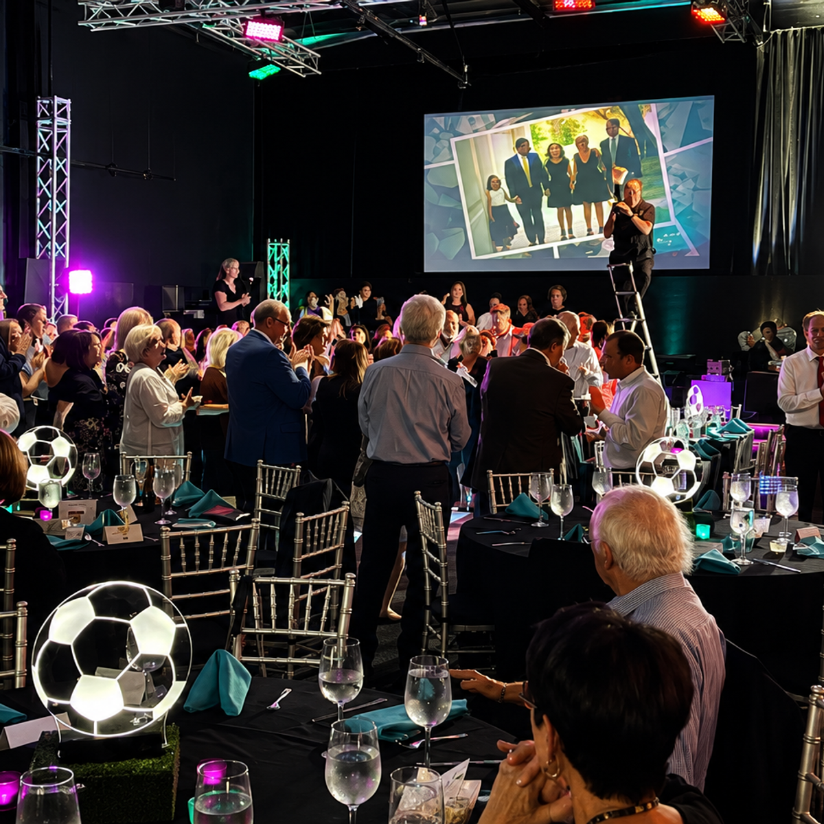 Gala dinner with big-screen presentation — black and teal accents