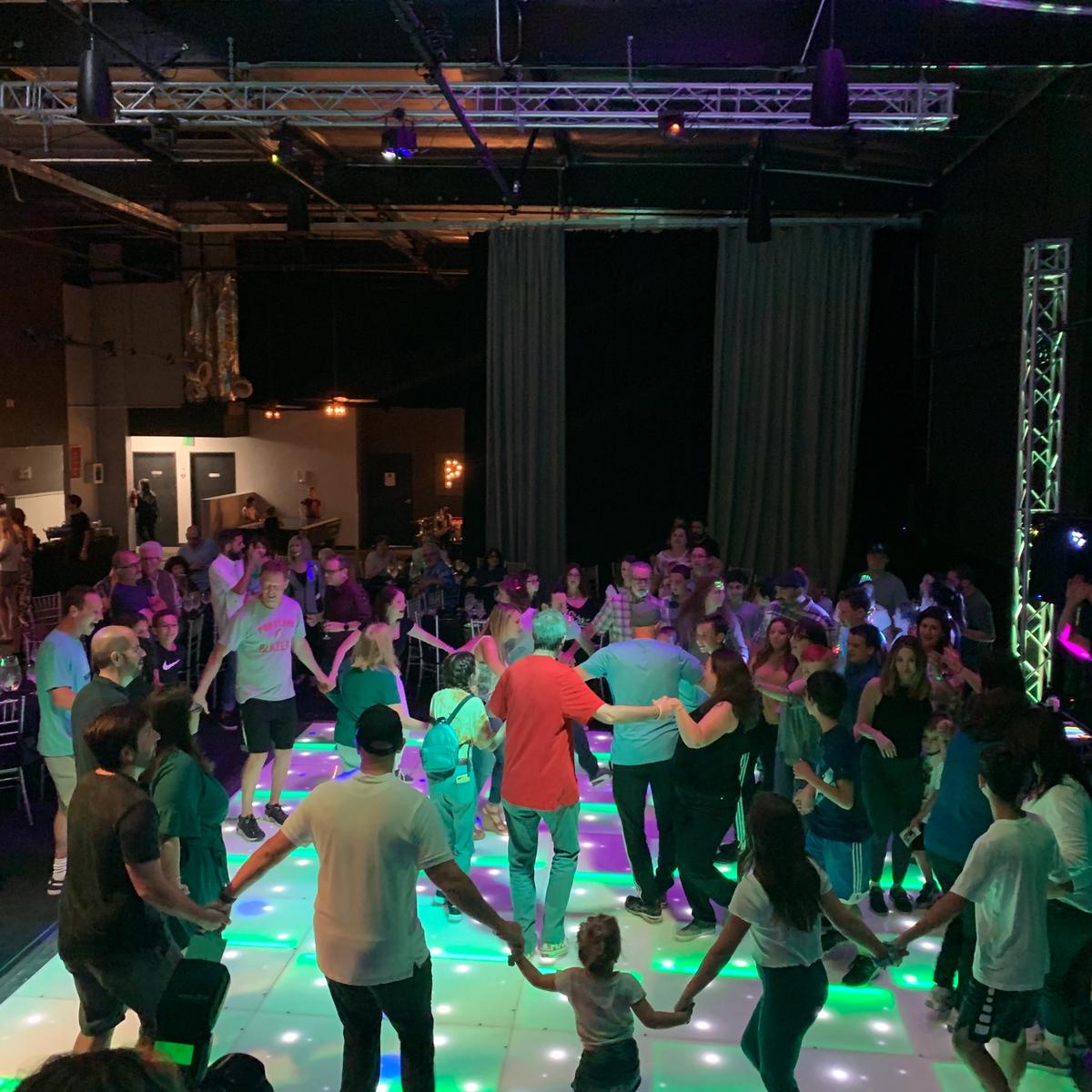 Guests dancing together on our color-changing LED dance floor