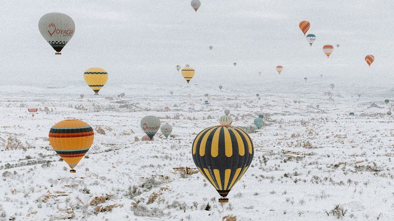 kar serpintili peri bacaları üzerinde balon uçuşu