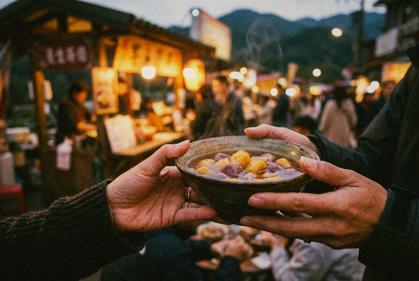 Two hands holding a warm bowl of chewy taro balls in sweet soup at a mountain-town market stall