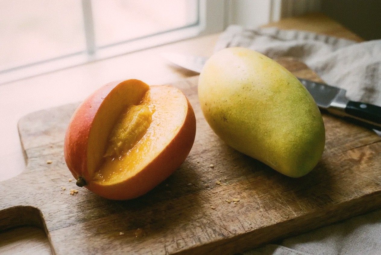 Close-up comparison of two types of Taiwan mangoes on a wooden cutting board
