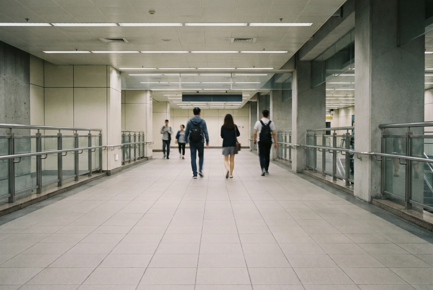 Illustration: Commuters walking through a station corridor.