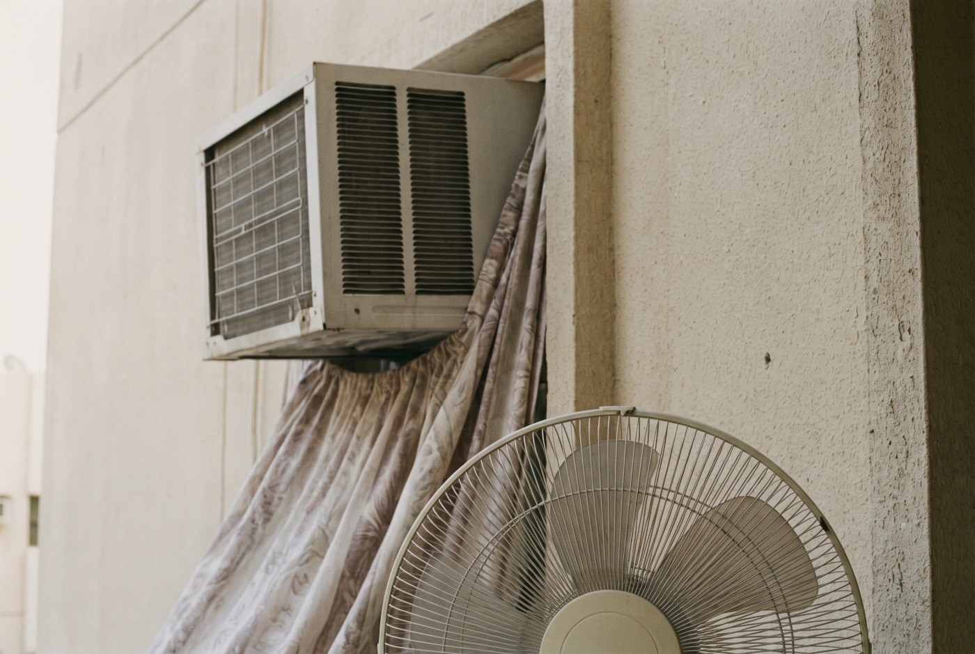 Illustration: An air conditioner and fan in a lived-in room.