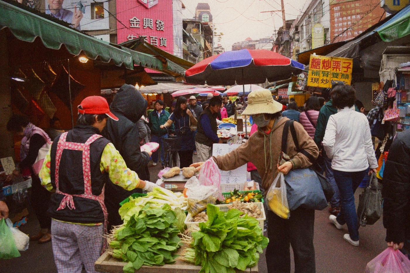A 自助餐 counter with food containers and a vendor serving portions