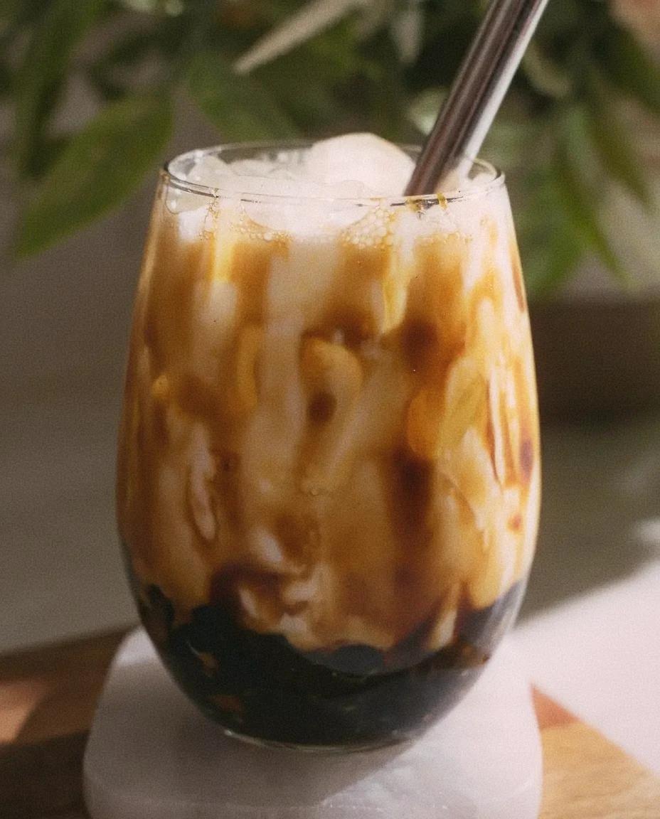 Close-up of brown sugar boba pearls in a cup of fresh milk