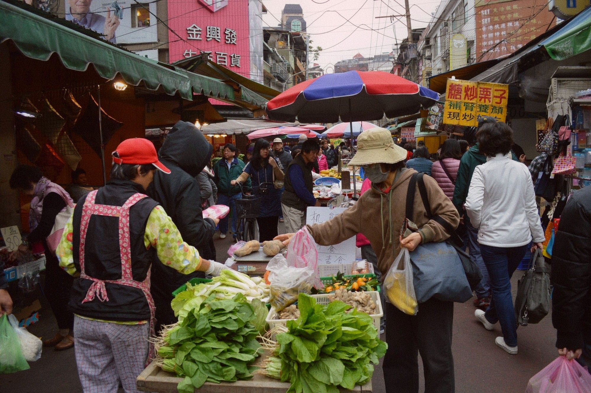 A 自助餐 counter with food containers and a vendor serving portions