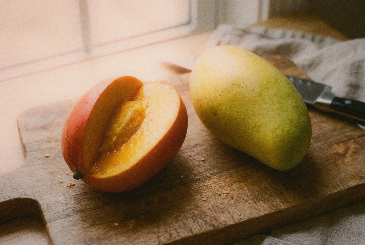 Close-up comparison of two types of Taiwan mangoes on a wooden cutting board