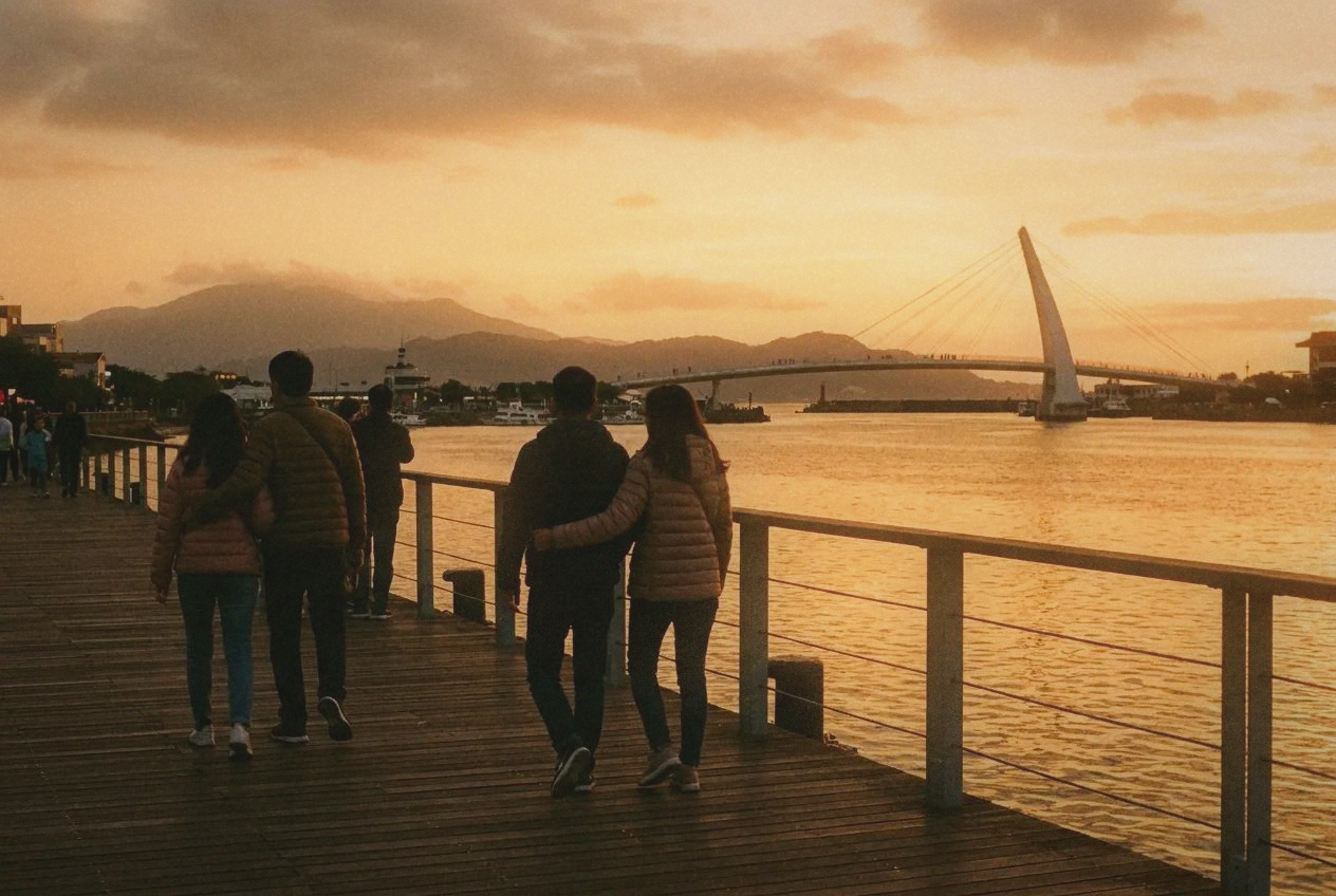 Tamsui waterfront boardwalk at sunset with golden river reflections