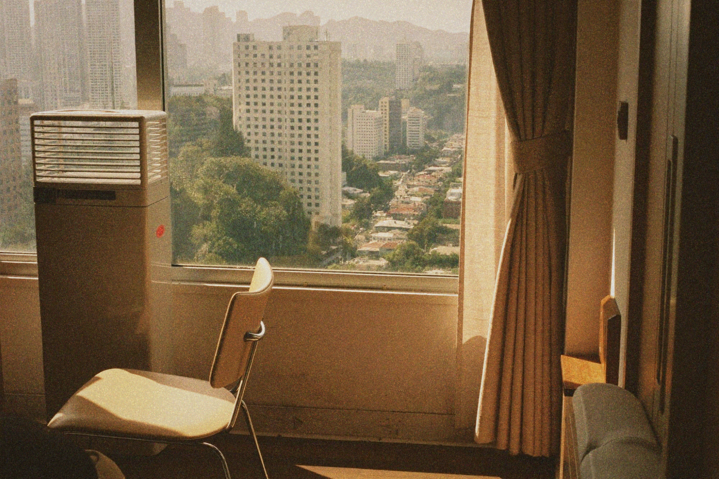View from a Taipei apartment window overlooking busy streets and urban buildings on a warm day