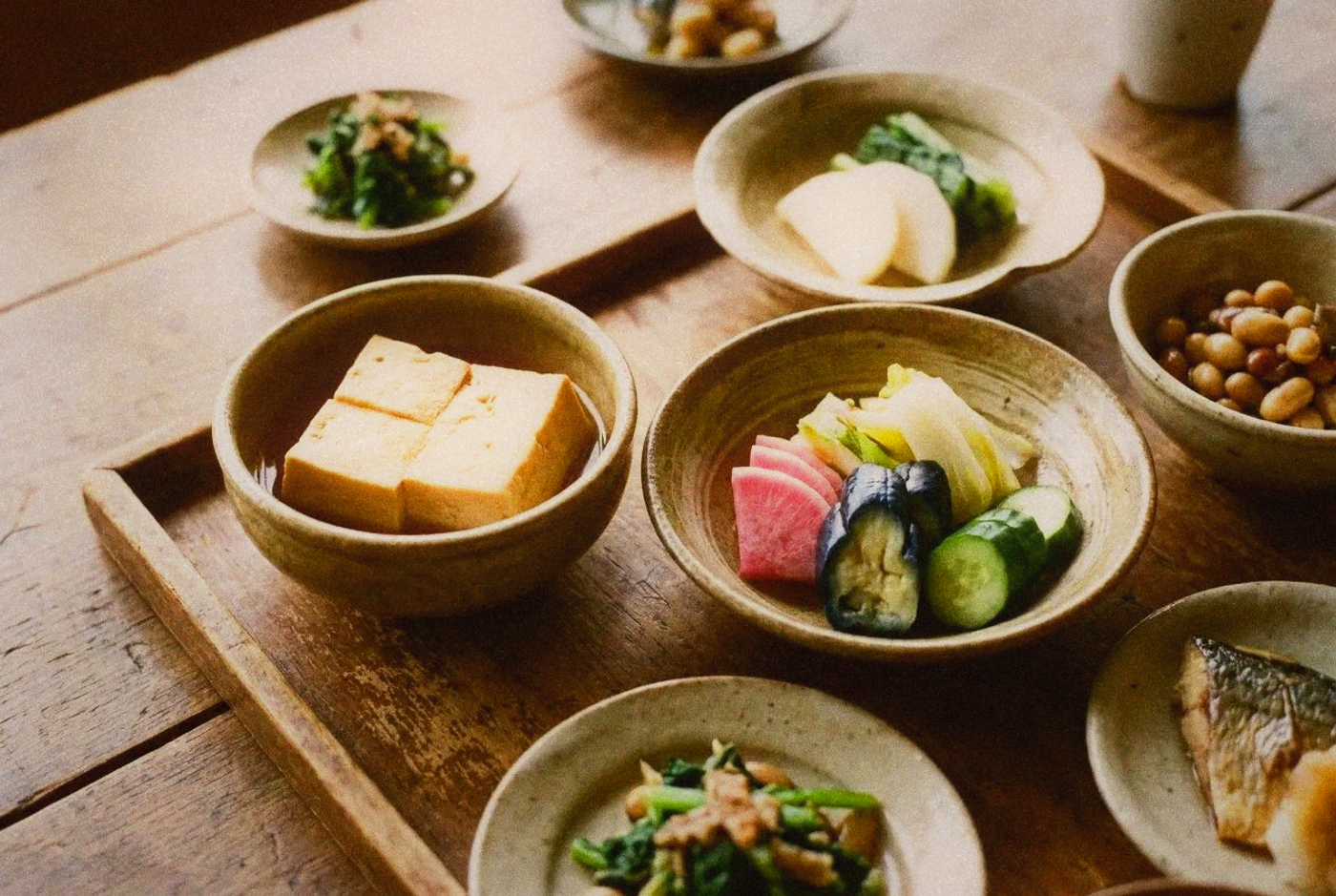 Arrangement of obanzai Kyoto home-style dishes in small ceramic bowls on a wooden tray